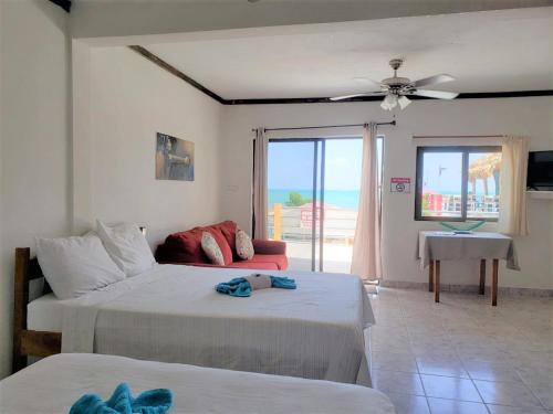 1 dormitorio con 2 camas y sala de estar en Beach Side Condos Caye Caulker by CCVH en Caye Caulker