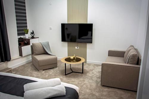 ein Wohnzimmer mit einem Sofa und einem TV in der Unterkunft Magnolija Apartments in Bitola