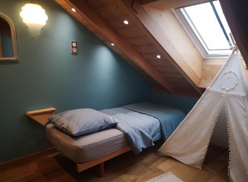 a bedroom with a bed and a ceiling with a window at Combles et Vous - COLMAR Gare - ALL INCLUSIVE - Jardin - 6 personnes - 1 lit bébé in Colmar