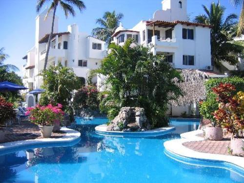 uma piscina em frente a um grande edifício em Hotel Villas Los Angeles em Manzanillo