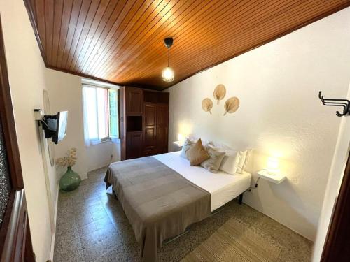 a bedroom with a large bed with a wooden ceiling at Historic Downtown Home By The Sea With King Bed in Monterosso al Mare