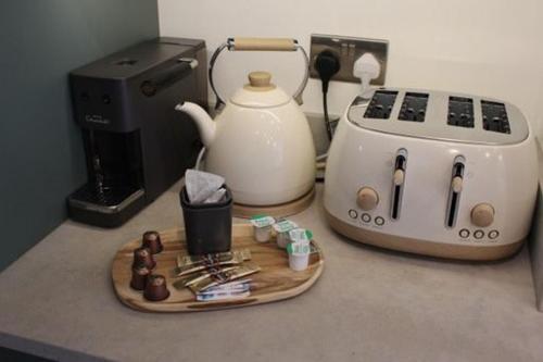 a counter top with a tea kettle and a toaster at Modern Townhouse in the heart of Beaumaris in Beaumaris