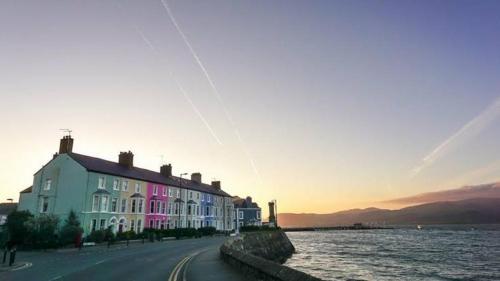 a group of buildings on a street next to a body of water at Modern Townhouse in the heart of Beaumaris in Beaumaris
