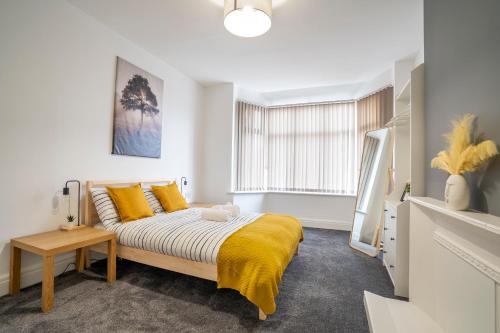 a bedroom with a bed with yellow pillows and a window at Quiet Neighborhood-Free Parking in Blackpool