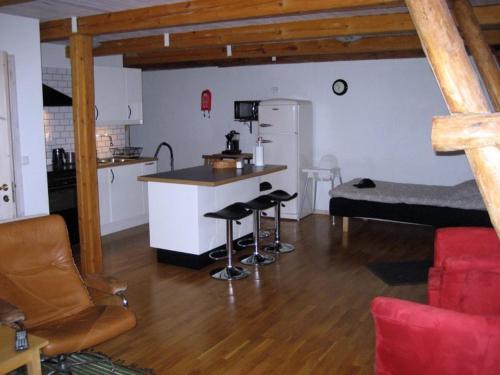 a living room with a kitchen and a bar in a room at Gårdsboende in Skårby