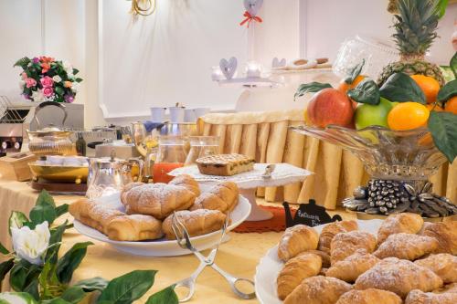 a table topped with plates of pastries and fruit at Hotel Royal in Bolsena