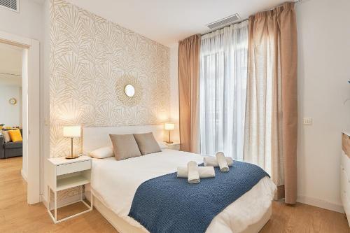 een slaapkamer met een groot bed met een blauwe deken bij Elite Beach in Málaga