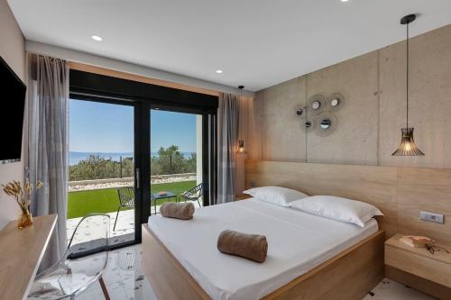 - une chambre avec un grand lit et une grande fenêtre dans l'établissement Villa Teraco, à Makarska