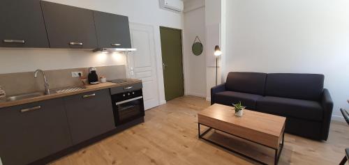 - une cuisine avec un canapé et une table dans une chambre dans l'établissement VALROSE, à Nice