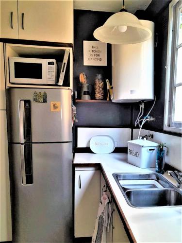 uma cozinha com um frigorífico de aço inoxidável e um lavatório em Las Cañitas em Buenos Aires