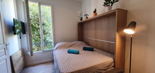 une chambre avec un lit avec deux oreillers bleus dessus dans l'établissement VALROSE, à Nice