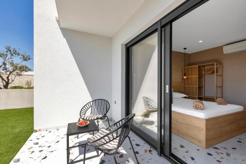 a bedroom with a bed and chairs on a balcony at Villa Teraco in Makarska