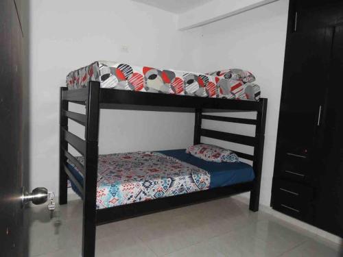 a black bunk bed with a blue mattress and a pillow at Apartamento familiar Obdulio in Villavicencio