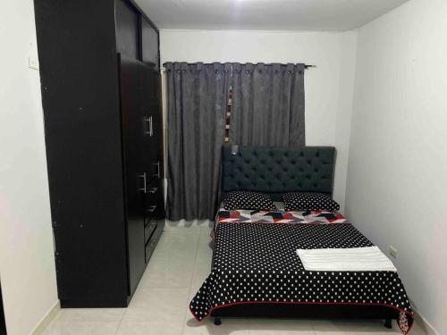 a bedroom with a bed and a chair in a room at Apartamento familiar Obdulio in Villavicencio