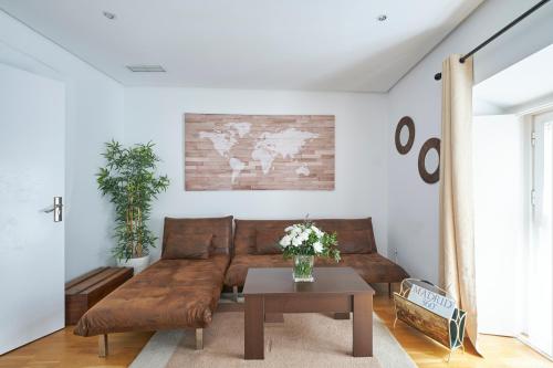 - un salon avec un canapé brun et une table dans l'établissement MAD COCO Aparts & Suites Centro Sol, à Madrid