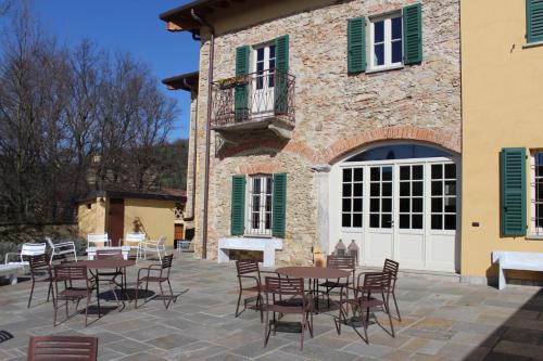 un patio con tavoli e sedie di fronte a un edificio di Il Colombee a Montevecchia