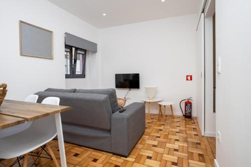 - un salon avec un canapé et une table dans l'établissement Douro Afurada Boutique Apartments, à Vila Nova de Gaia