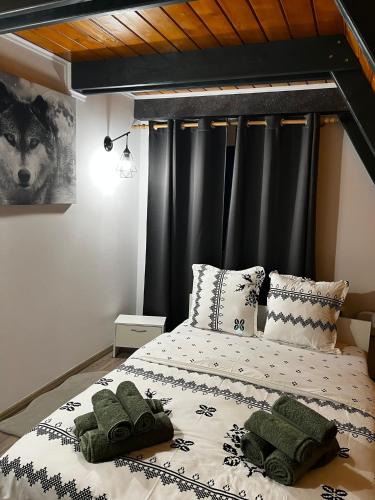 a bedroom with a large bed with black curtains at La KOLTAU A-Frame in Mărişel