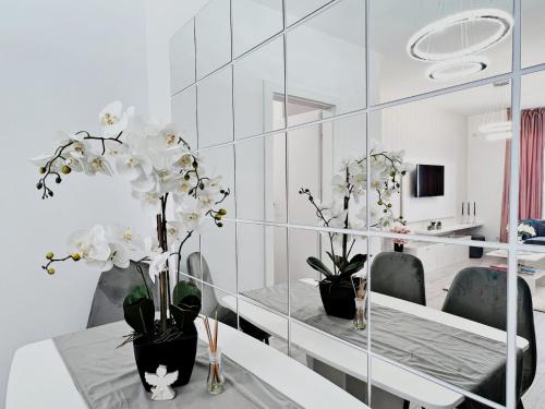 uma sala de jantar com uma mesa com flores brancas em Apartament Antonia em Sibiu