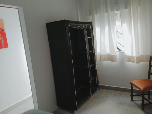a black refrigerator in the corner of a room at Apartamentos Lax in Almería