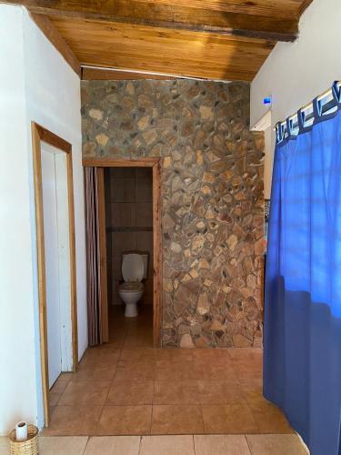 baño con pared de piedra y aseo en Quinta en Villa Constitución