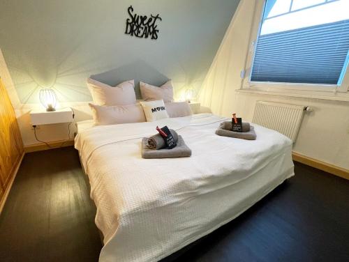 a bedroom with a large white bed with towels on it at Familienfreundliches Ferienhaus in 5 min zum Strand mit Terrasse und kostenlosem Parkplatz in Cuxhaven