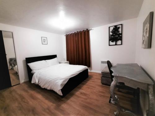 um quarto com uma cama e uma secretária. em 3 Bedroom Semi Detached House with parking, WiFi em Colchester