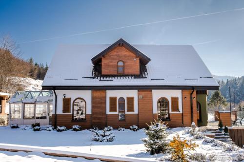 a wooden house with snow on the ground at Rita Art Chalet Voronet in Voroneţ