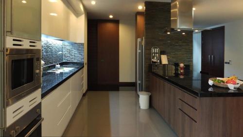 a kitchen with black counter tops and a large appliance at Karon Suite Apartment in Karon Beach