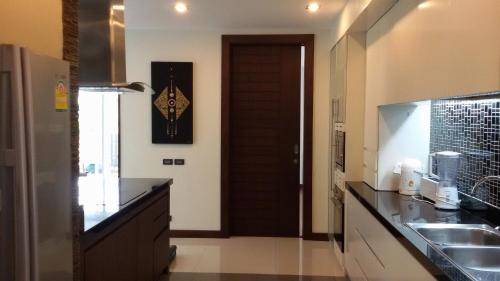 a kitchen with a sink and a brown door at Karon Suite Apartment in Karon Beach