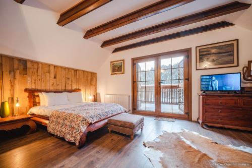 a bedroom with a bed and a flat screen tv at Rita Art Chalet Voronet in Voroneţ