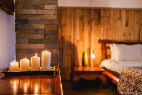 a room with candles on a table next to a bed at Rita Art Chalet Voronet in Voroneţ