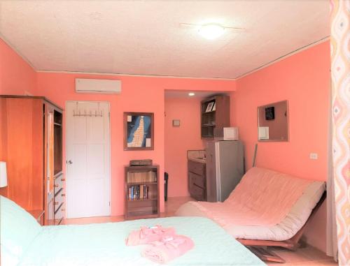 a bedroom with two beds and a refrigerator in it at Beach Side Condos Caye Caulker by CCVH in Caye Caulker