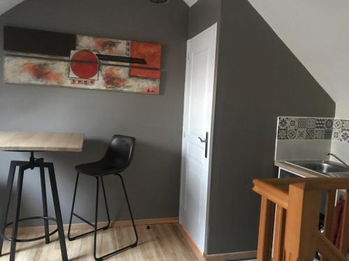 a kitchen with a sink and a table and stool at Chez Chris in Oloron-Sainte-Marie