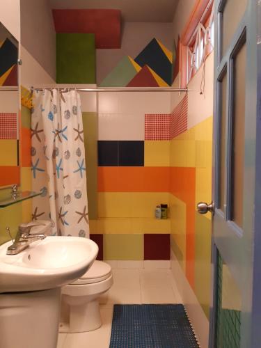 a colorful bathroom with a toilet and a sink at Tonkin Homestay in Hanoi