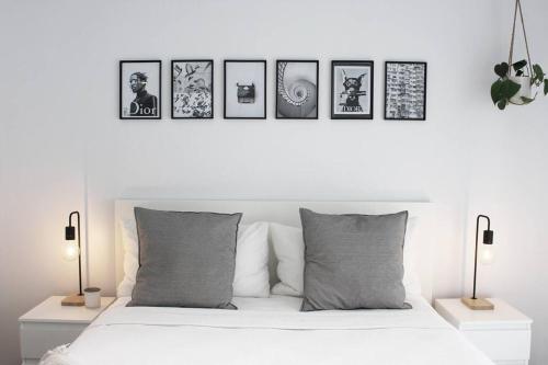 a bedroom with a white bed with four pictures on the wall at Beach Side Villa Walk to Shops-Pub-Beach in Byron Bay