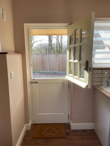 a kitchen with a door and a window at Beech Cottage in Bodiam