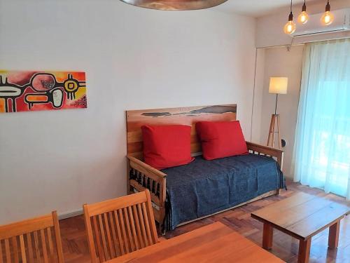 - une chambre avec un lit doté d'oreillers rouges et d'une table dans l'établissement Departamento Congreso, à Buenos Aires