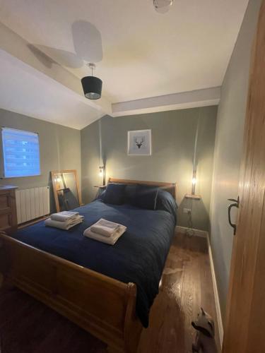 a bedroom with a bed with two towels on it at Beech Cottage in Bodiam