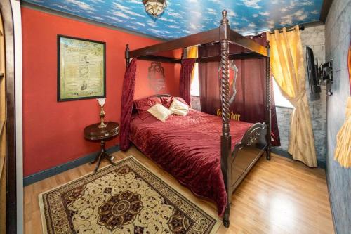 a bedroom with a canopy bed and a red wall at Hogwarts Hideaway Themed Property in Garston