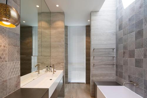 uma casa de banho com 2 lavatórios e um espelho em The Ivy Box Apartment em Queenstown