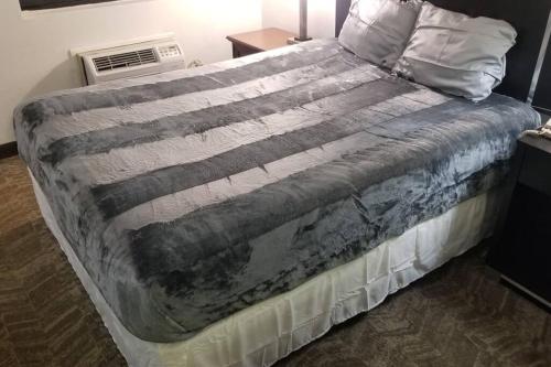 a bed with a blanket on it in a bedroom at Hotel 2 Queen Beds Room 124 Booking in Stillwater