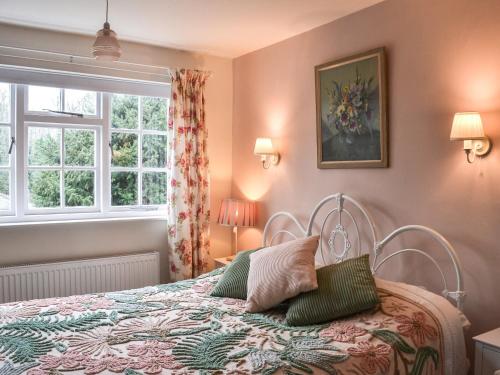 a bedroom with a bed and a window at Coopers Cottage in Louth
