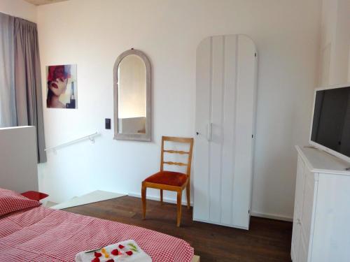 1 dormitorio con cama, silla y espejo en Cologne Country Lodge en Colonia