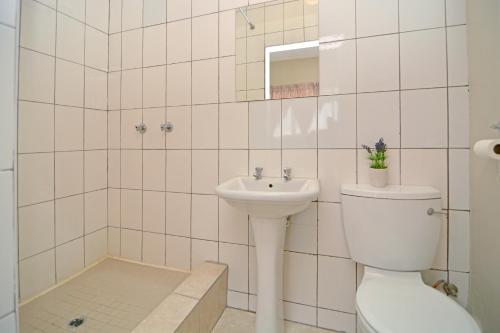 La salle de bains est pourvue de toilettes et d'un lavabo. dans l'établissement The Westpoint -Modern ,secure apartment, à Roodepoort