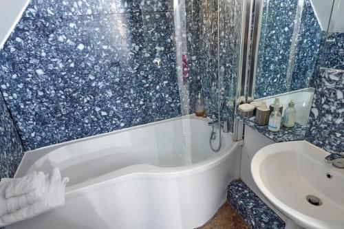 a bathroom with a tub and a sink at The Penthouse in King's Lynn