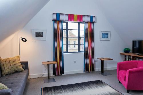 a living room with a couch and a window at The Penthouse in King's Lynn