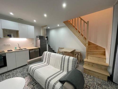 un salon avec un canapé et une cuisine dans l'établissement maison F3 « Ô meublé de Pithiviers » 6 lits- 7 personnes, à Pithiviers