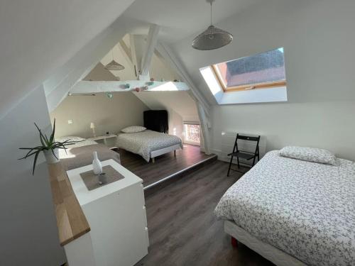 a bedroom with two beds and a room with a window at maison F3 « Ô meublé de Pithiviers » 6 lits- 7 personnes in Pithiviers