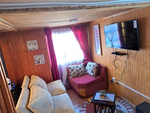 - un salon avec un canapé et une télévision dans l'établissement Cabaña Alba, à Puerto Montt